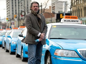 London Taxi Association spokesperson Roger Caranci, standing beside a row of taxis awaiting customers outside the VIA Rail station in London, says the association is launching a social media campaign on the benefits of taxis over Uber drivers.