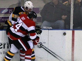 Kingston Frontenacs’ Lawson Crouse and Ottawa 67's Nevin Guy battle for the puck during an Ontario Hockey League game at the Rogers K-Rock Centre on Wednesday night. (Steph Crosier/The Whig-Standard)