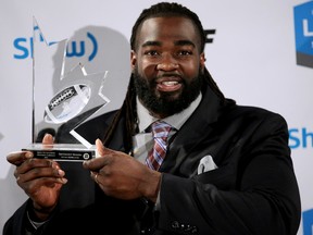 Ottawa RedBlacks' SirVincent Rogers holds his trophy after winning the Canadian Football League's Most Outstanding Offensive Lineman during the annual Shaw CFL Awards ahead of the 103rd Grey Cup in Winnipeg, Man., on Thursday November 5, 2015. Al Charest/Calgary Sun/Postmedia Network