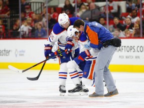 Injured Oilers forward Nail Yakupov is helped off the ice by trainer TD Forss and teammate Mark Frayne during Wednesday/'s game against the Hurricanes in Raleigh, N.C. (USA TODAY SPORTS)
