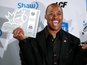 Ottawa RedBlacks' Henry Burris holds the Tom Pate Memorial Award and the Canadian Football League's Most Outstanding Player trophy during the annual Shaw CFL Awards ahead of the 103rd Grey Cup in Winnipeg, Man., on Thursday November 5, 2015. (Al Charest/Postmedia Network)