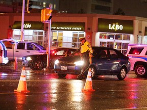 Const. Rick Carr of the Greater Sudbury Police Service traffic management unit prepares to take measurements at a collision in which two pedestrians were struck at the Lloyd Street Hill on Thursday. Gino Donato/Sudbury Star/Postmedia Network