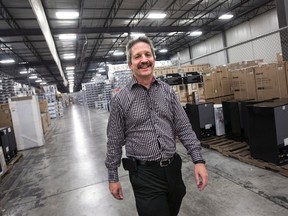 Jim Estill, president and CEO of Danby, walks through the company's warehouse in Guelph, Ont. on Friday, Nov. 27, 2015. Estill is donating up to $1.5 million to support 50 Syrian refugee families in their first year of settlement. THE CANADIAN PRESS/Darren Calabrese