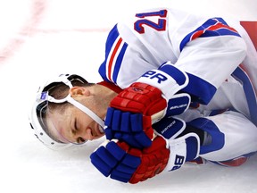 New York Rangers centre Derek Stepan (21) grimaces as he lies on the ice after being checked into the boards by Boston Bruins winger Matt Beleskey Friday at TD Garden. (Winslow Townson/USA TODAY Sports)