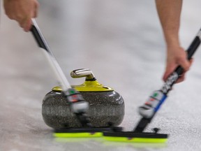 Curlers sweep a rock during the Travelers Curling Club Championship at the Ottawa Hunt and Golf Club on Tuesday, Nov. 24, 2015. (Errol McGihon/Postmedia Network)