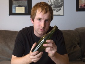 Jon Crouse displays a century-old beer bottle at home in Lower Sackville, N.S. on Thursday, Nov. 26, 2015. Crouse discovered it while scuba diving in Halifax's Northwest Arm and later traced its origin by the markings on the bottle. Printing on the cork says, “A. Keith & Son Brewery,” the previous name of the now famous Halifax-based Alexander Keith’s brewing company, which opened in the early 1820s. THE CANADIAN PRESS/Andrew Vaughan