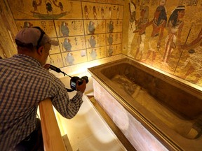 A photographer taking pictures of the golden sarcophagus of King Tutankhamun in his burial chamber is seen in the Valley of the Kings, in Luxor, Egypt, November 28, 2015. Chances are high that the tomb of Ancient Egypt's boy-king Tutankhamun has passages to a hidden chamber, which may be the last resting place of Queen Nefertiti, and new evidence from the site will go to Japan for analysis, experts said on Saturday. REUTERS/Mohamed Abd El Ghany