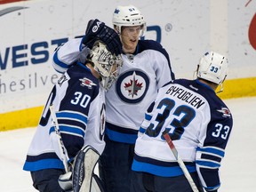 Winnipeg Jets goalie Connor Hellebuyck (30) celebrates with defenseman Tyler Myers (57) and defenseman Dustin Byfuglien (33) following the game against the Minnesota Wild on Friday. The Jets visit Colorado for a Saturday night game with the Avalanche. (Brace Hemmelgarn-USA TODAY Sports)