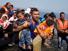 Syrian refugees arrive aboard a dinghy after crossing from Turkey to the island of Lesbos, Greece, in this Sept. 10, 2015 file photo. When Syrian refugees begin arriving in Canada in the coming weeks, one of the top priorities will be providing the migrants with primary health care, from vaccinating children against infectious diseases to screening and treating adults for chronic conditions like diabetes and heart disease, doctors say. THE CANADIAN PRESS/AP-Petros Giannakouris, File