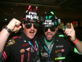 Regular Grey Cup attendees Corey Pusey (left) of Red Deer and Dave Hanni of Medicine Hat ham it up at the Riderville party as part of the Grey Cup Festival in Winnipeg. (BRIAN DONOGH/Postmedia Network)