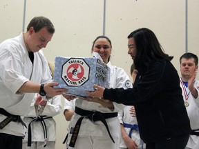 Hanshi Ken Tallack, Kyle Cochrane, and Melanie Loxton of Ken Tallack's Martial Arts, present Elizabeth Kim, Christmas Hamper and sponsorship coordinator for the Salvation Army, with $2,863 in Kingston, Ont. on Saturday November 28, 2015. The money was raised by martial arts students as part of Ken Tallack's Martial Arts Fundraiser for Salvation Army Christmas Hamper Campaign Steph Crosier/Kingston Whig-Standard/Postmedia Network