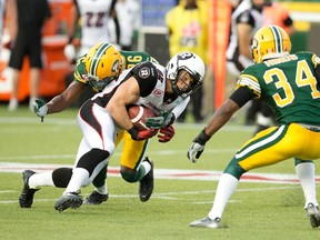 Ottawa Redblacks' Greg Ellingson (82) is tackled by Edmonton Eskimos' John Ojo (26) and Ryan Hinds (34) during second half action in Edmonton, Alta., on Thursday July 9, 2015. The Eskimos take on the Redblacks in the CFL 103rd Grey Cup championship football game in Winnipeg, Manitoba on November 28, 2015. (THE CANADIAN PRESS/Jason Franson)