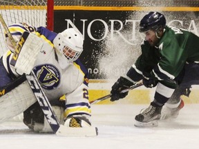 Nipissing Lakers captain Dane Horvat sprays snow as he brakes at the Laurentian Voyageurs net while goalie Alain Valiquette covers the puck during OUA action at Memorial Gardens, Saturday. Laurentian won 4-2. Dave Dale/The Nugget
