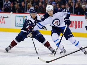 Colorado Avalanche left winger Andrew Agozzino is pushed away by Winnipeg Jets center Mark Scheifele (55) during the first period of an NHL hockey game Saturday, Nov. 28, 2015, in Denver. (AP Photo/Jack Dempsey)