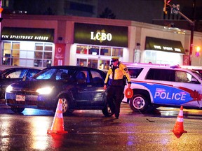 Const. Rick Carr of the Greater Sudbury Police Service prepares to take measurements at a collision in which two pedestrians were struck at the Lloyd Street hill on Thursday, Nov. 26, 2015. Gino Donato/Sudbury Star/Postmedia Network
