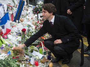 Canadian Prime Minister Justin Trudeau lays a flower at a memorial outside the Bataclan cafe Sunday November 29, 2015 in Paris, France. Trudeau is in Paris to attend the United Nations climate change summit. THE CANADIAN PRESS/Adrian Wyld