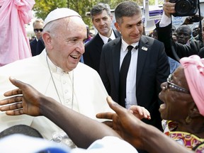 Pope Francis talks with a woman as he visits the refugee camp of Saint Sauveur in the capital Bangui, Central African Republic, November 29, 2015. REUTERS/Stefano Rellandini