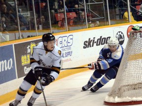 London defenseman Olli Juolevi (left) cuts around his net while the Owen Sound Attack's Kevin Hancock tries to put the hook on him during the Knights 4-1 win on Saturday in Ontario Hockey League action.