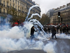 Protestors clash with riot police during a rally against global warming on November 29, 2015 in Paris, a day ahead of the start of UN conference on climate change COP21. Paris riot police fired teargas November 29 in clashes with far-left activists in Paris during a climate change demonstration ahead of key UN talks after several thousand protesters had formed a human chain in the city. AFP PHOTO / FLORIAN DAVID