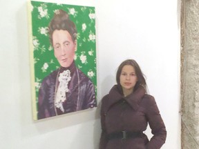 Eve Nicholson-Smith standing beside her portrait called Margaret Tucker, who was her great-great-grandmother.