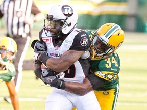 Ottawa Redblacks' Jock Sanders (19) is tackled by Edmonton Eskimos' Ryan Hinds (34) during first half action in Edmonton, Alta., on Thursday July 9, 2015. THE CANADIAN PRESS/Jason Franson.