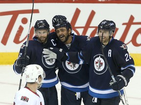 Winnipeg Jets left winger Andrew Ladd (l) celebrates his third period goal against the Ottawa Senators with teammates Dustin Byfuglien (c) and Blake Wheeler during NHL hockey in Winnipeg, Man. Tuesday September 29, 2015. The Jets defeated the Senators 4-3.
Brian Donogh/Winnipeg Sun/Postmedia Network