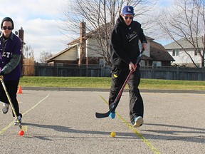 Colton Bond, a social service worker program student at Lambton College, left, and sexual assault survivor Paulie O'Byrne demonstrate a stickhandling obstacle course in the college parking lot Sunday. Students were raising funds and awareness for the Sarnia-Lambton Sexual Assault Survivors' Centre, and O'Byrne was speaking at the event. (Tyler Kula, The Observer)