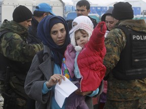 Refugees are seen entering into Macedonia on Saturday Nov. 28.  (AP Photo/Boris Grdanoski)