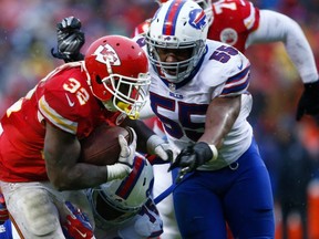 Spencer Ware #32 of the Kansas City Chiefs is tackled by Jerry Hughes #55 of the Buffalo Bills at Arrowhead Stadium during the third quarter of the game on November 29, 2015 in Kansas City, Missouri.   Jamie Squire/Getty Images/AFP