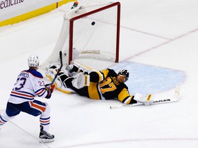 Edmonton Oilers' Matt Hendricks (23) gets the puck over Pittsburgh Penguins' Jeff Zatkoff (37) for a shootout goal during an NHL hockey game in Pittsburgh Saturday, Nov. 28, 2015. The Oilers won 3-2. (AP Photo/Gene J. Puskar)