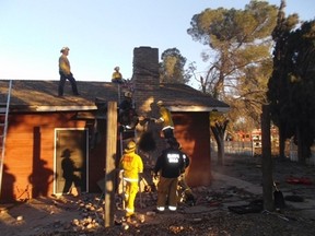 Local fire and sheriff personnel respond to a home after a suspected burglar got stuck in the chimney and died in Fresno, California November 29, 2015. A suspected burglar who attempted to enter a California home through the chimney died on Saturday after the homeowner lit a fire without realizing anyone was inside, police said.  REUTERS/Fresno County Sheriff's Office/Handout via Reuters