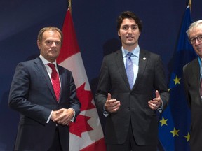 European Council President Donald Tusk, left, and European Commission President Jean-Claude Juncker, right, listen as Canadian Prime Minister Justin Trudeau makes some opening remarks before a bilateral meeting at the United Nations climate change summit in Le Bourget, France, on Nov. 30, 2015. (THE CANADIAN PRESS/Adrian Wyld)