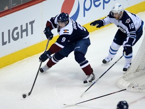 Colorado Avalanche center Matt Duchene (9) attempts to pass the puck as Winnipeg Jets center Bryan Little (18) defends in the first period at the Pepsi Center.
