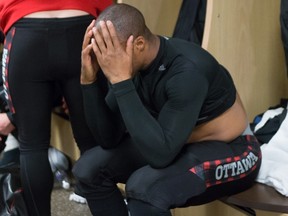 Redblacks quarterback Henry Burris buries his face in his hands as he sits in the locker room after losing the 103rd Grey Cup to the Edmonton Eskimos in Winnipeg, Man., Sunday, Nov. 29, 2015. 
THE CANADIAN PRESS/John Woods