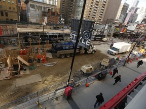 Workers try to determine what caused a deep sinkhole on the west side of Yonge St. just north of College St. Monday November 30, 2015. (Jack Boland/Toronto Sun)