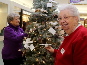 Tettje Zuidema (back) and Cathie Price volunteer at the Hospice Quinte Memorial Trees at the Quinte Mall on Monday.