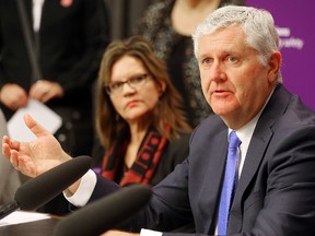 Attorney General Gord Mackintosh (r) releases his legislation on domestic violence as Trudy Lavallee, executive director of Ikwe Widdjiitiwin, looks on at a press conference in Winnipeg, Man. Monday November 30, 2015.