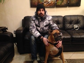 Steven Shpak, 34, and his seven-year-old boxer, Stella, Monday, Nov. 30, 2015. Stella became ill after eating a green-tinted pet treat found in a park outside their apartment building at 85 Thorncliffe Park Dr. (Terry Davidson/Toronto Sun)