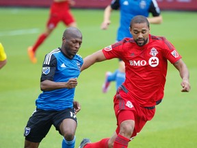 Toronto FC's Justin Morrow (right) jostles for ball with San jose Earthquakes' Sanna Nyassi (left) during first half  MLS action in Toronto on May 30, 2015. (Jack Boland/Toronto Sun)
