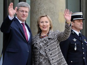 Hillary Clinton, former U.S. Secretary of State, and Stephen Harper (L) wave as they arrive at the Elysee Palace in Paris on March 19, 2011. Newly released Clinton emails show a U.S. official expressed amazement at how disliked Harper's Conservative government was by some employees of the Foreign Affairs Department. REUTERS/Gonzalo Fuentes