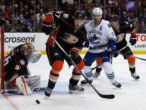 Ducks goalie John Gibson watches the puck as teammate Hampus Lindholm (47) battles with Canucks forward Daniel Sedin (22) during the second period NHL action in Anaheim on Monday, Nov. 30, 2015. (Sean M. Haffey/Getty Images/AFP)