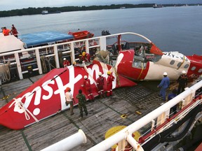 In this Sunday, Jan. 11, 2015 file photo, crew members of Crest Onyx recovery ship prepare to unload the newly-recovered tail section of crashed AirAsia Flight 8501 at Kumai port in Pangkalan Bun, Central Borneo, Indonesia. (AP Photo/Achmad Ibrahim, File)