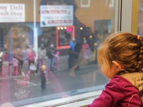 Everleigh watching the Santa Claus parade in Strathroy on Saturday, Nov. 21, from the second floor of the Royal Bank of Canada branch, as the weather, while sitting at 0 C, was too cold for her to watch the whole parade from the street. JONATHAN JUHA/STRATHORY AGE DISPATCH/POSTMEDIA NETWORK