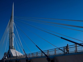 A man walks across Esplanade Riel on Monday. (THE CANADIAN PRESS/Darryl Dyck)