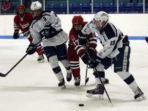 Woodstock Navy Vets defenceman Austin Whetham, right, tries to clear the zone before Norwich Merchants forward Ray Munro can get to the puck in Norwich, Ont. on Sunday November 29, 2015. The Merchants won 7-4 for their fifth win in their last six games. Greg Colgan/Woodstock Sentinel-Review/Postmedia Network