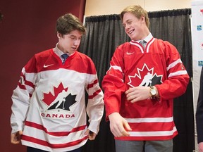 Hockey players Mitchell Marner and Lawson Crouse put on the Team Canada jersey during a press conferences in Toronto on Thursday, December 1, 2015 after Hockey Canada announced the 30 players invited to attend Canada's national junior team selection camp before the upcoming IIHF World Junior Championships. (THE CANADIAN PRESS/Nathan Denette)