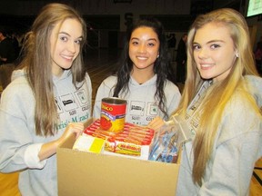 St. Patrick's Catholic High School Grade 11 students, from left, Alex Gouveia, Noelle Allen and Shayna Robertson hold a box of food on hand for an Irish Miracle pep rally on Tuesday December 1, 2015 in Sarnia, Ont. Hundreds of the school's student are expected to be out Saturday morning in Sarnia and Point Edward knocking on doors and collecting non-perishable food to help fill Christmas hampers.
Paul Morden/Sarnia Observer/Postmedia Network