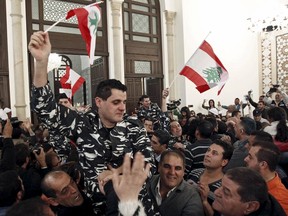 Lebanese soldiers and policemen who were captured by the al-Qaida-linked Nusra Front in Arsal, celebrate carrying Lebanese flags upon their arrival in Beirut, Lebanon, on Dec. 1, 2015. (REUTERS/Mohamed Azakir)