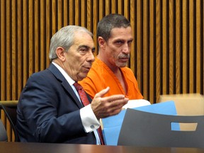 Bobby Hernandez, right, listens to defense attorney Ralph DeFranco in Cuyahoga County Common Pleas Court before pleading not guilty to kidnapping and other charges on Tuesday, Dec. 1, 2015 in Cleveland. Authorities allege Hernandez took his 5-year-old son from an Alabama home in 2002 and created a life for them in Ohio under new identities, a ruse discovered through discrepancies with the boy's Social Security number as he began the college application process. (AP Photo/Kantele Franko)