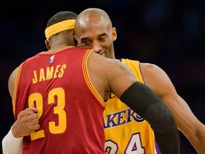 In this Jan. 15, 2015, file photo, Los Angeles Lakers guard Kobe Bryant, right, and Cleveland Cavaliers forward LeBron James hug before the start of an NBA basketball game in Los Angeles. (Paul Rodriguez/The Orange County Register via AP)